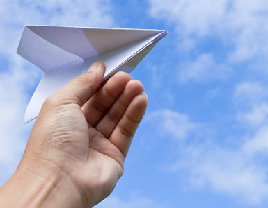 A hand is flying paper plane and dreaming to do MBA in Aviation Management