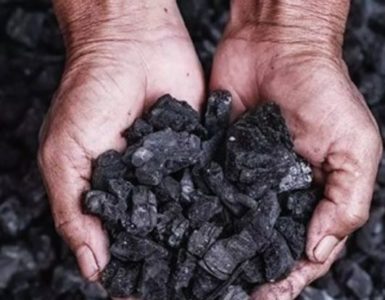 Hands holding coal depicting coal crisis in india (power management)